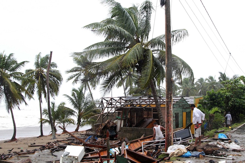 People look at what is left of their home in the Dominican Republic.