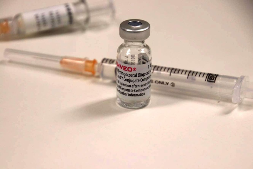 Two syringes and a small glass vial of vaccine.