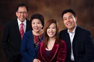 Curtis Cheng, wearing a suit, poses for a family photo.