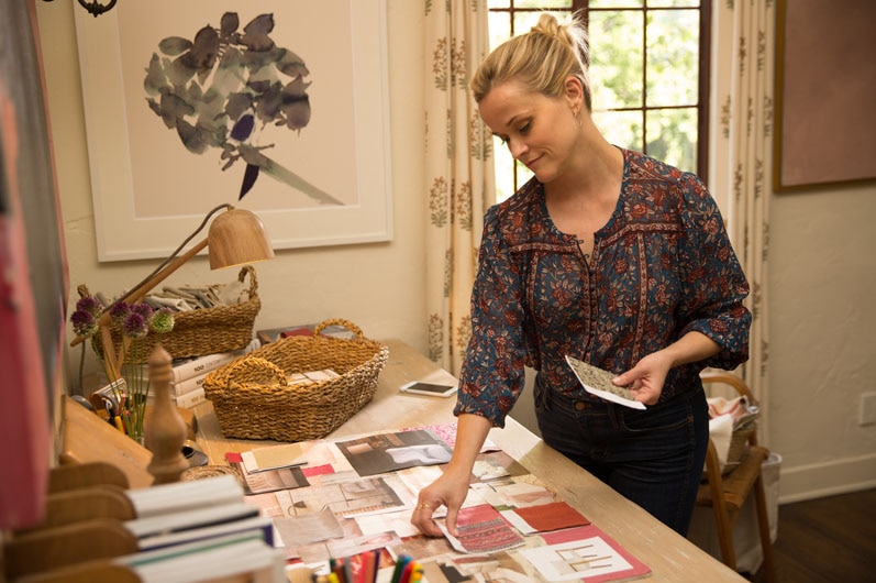 Still image of actor Reese Witherspoon in 2017 film Home Again, working on an interior designer mood board.