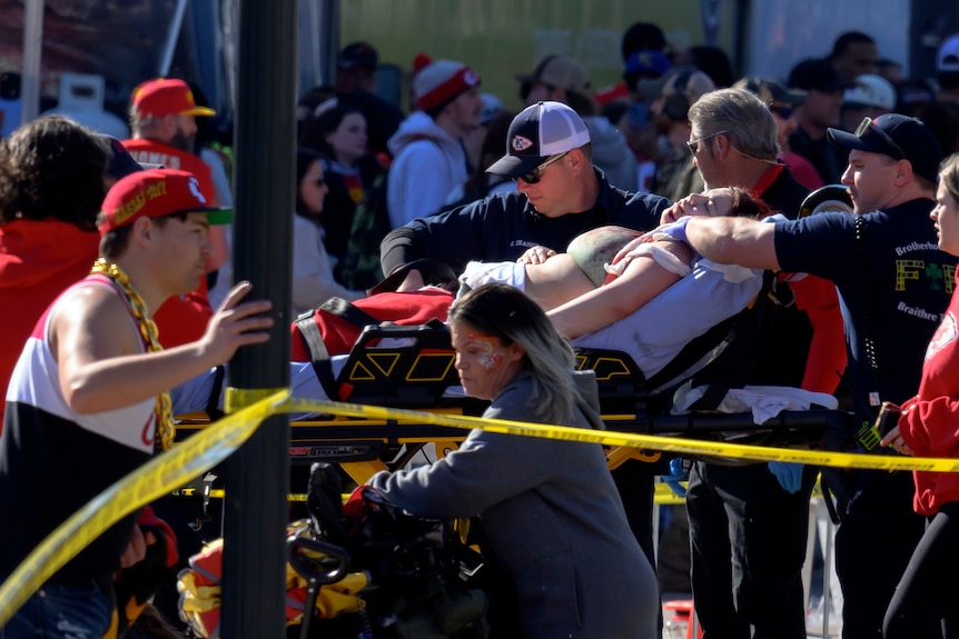 A woman is rushed to an ambulance on a stretcher.