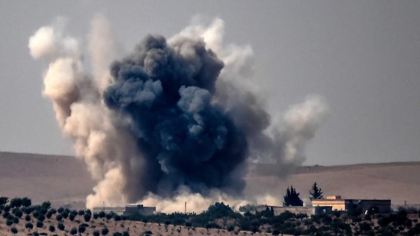 Smoke billows following air strikes by a Turkish Army jet fighter on the Syrian Turkish border village of Jarabulus.