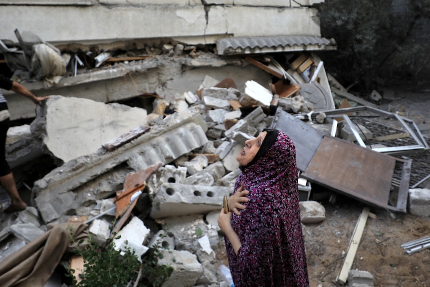 A Palestinian woman reacts at the site of an Israeli strike on a residential building in Gaza City 