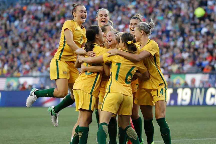 Australian players jump up together as they celebrate a goal against United States.