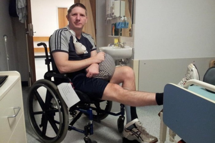 Anthony Fox sits in a wheel chair in a hospital room, after suffering a golden staph infection following a stroke.