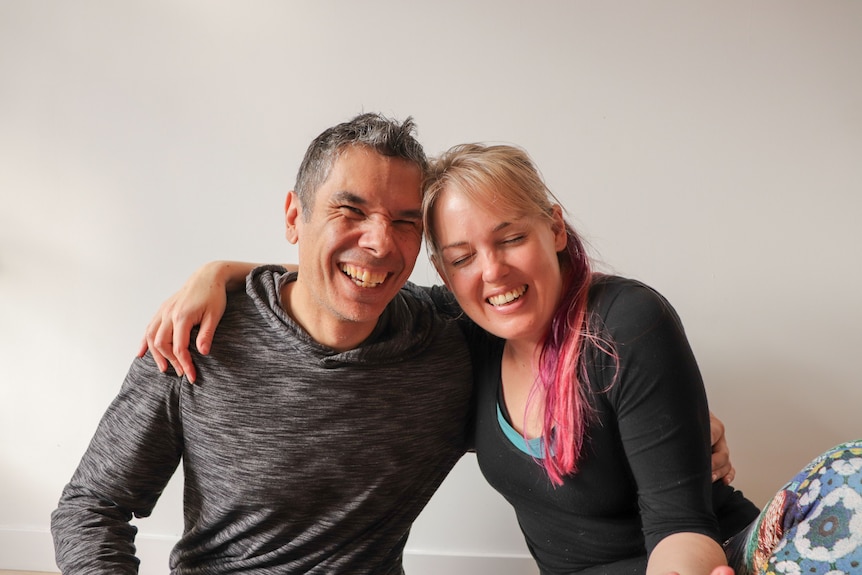 A man and a woman with with arms around each other and smiling, this couple seek alone time whilst enjoying their relationship