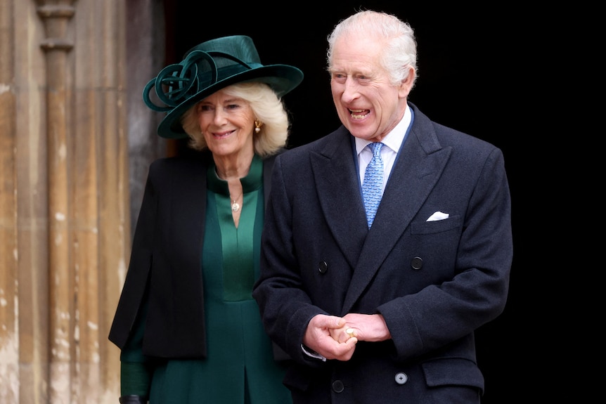 King Charles and Queen Camilla  smile as they walk out of church.