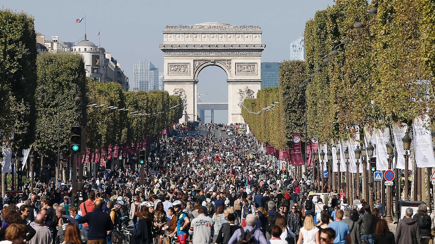 People walk and cycle along the Champs Elysee Avenue during the "Car-Free Day" event taking place in the French capital Paris.