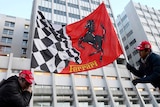 Fans hold a Ferrari flag outside the Grenoble University Hospital Centre in the French Alps.