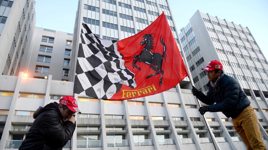 Fans hold a Ferrari flag outside the Grenoble University Hospital Centre in the French Alps.