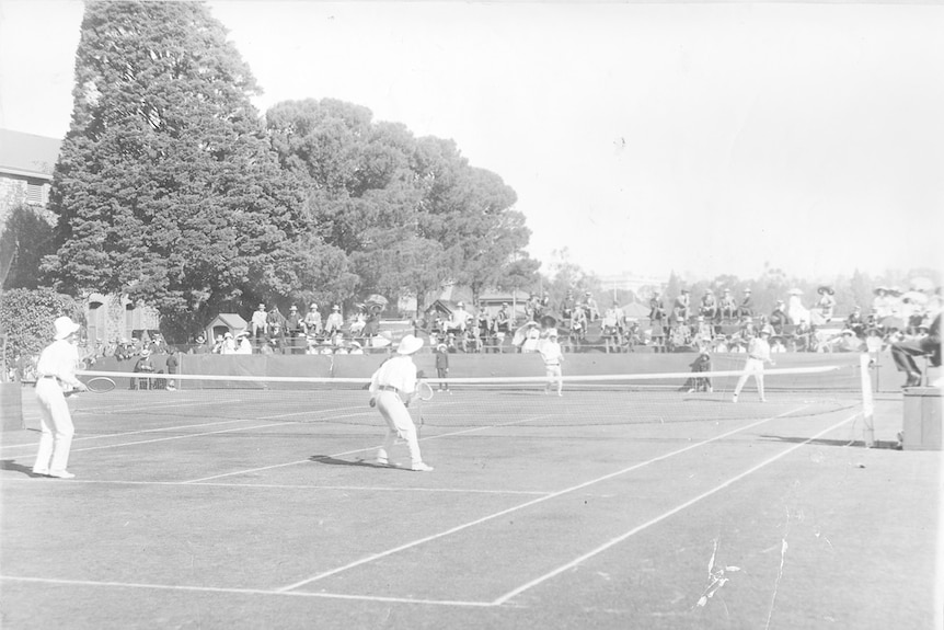 A men's doubles tennis match being played at the Adelaide Oval tennis courts.