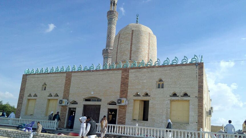 Mosque in Sinai Province and people walking outside the building.