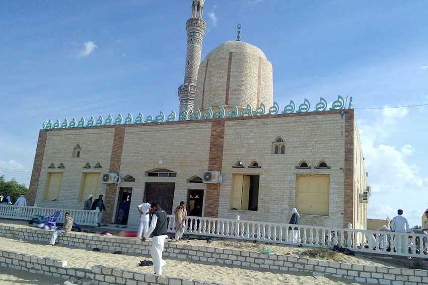 Mosque in Sinai Province and people walking outside the building.