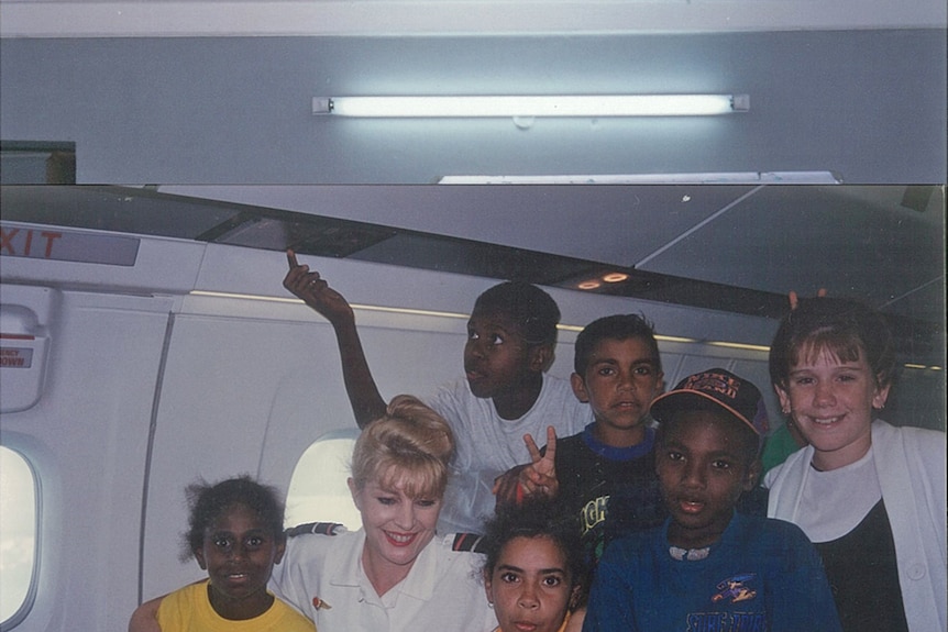 Young children from the Torres Strait surround Ronni on a Dash 8