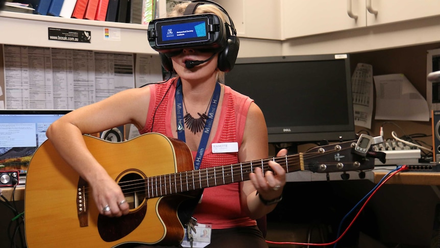 Study lead Jeanette Tamplin strums the guitar during a virtual reality singing session.