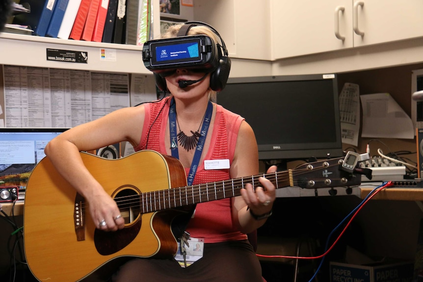 Study lead Jeanette Tamplin strums the guitar during a virtual reality singing session.