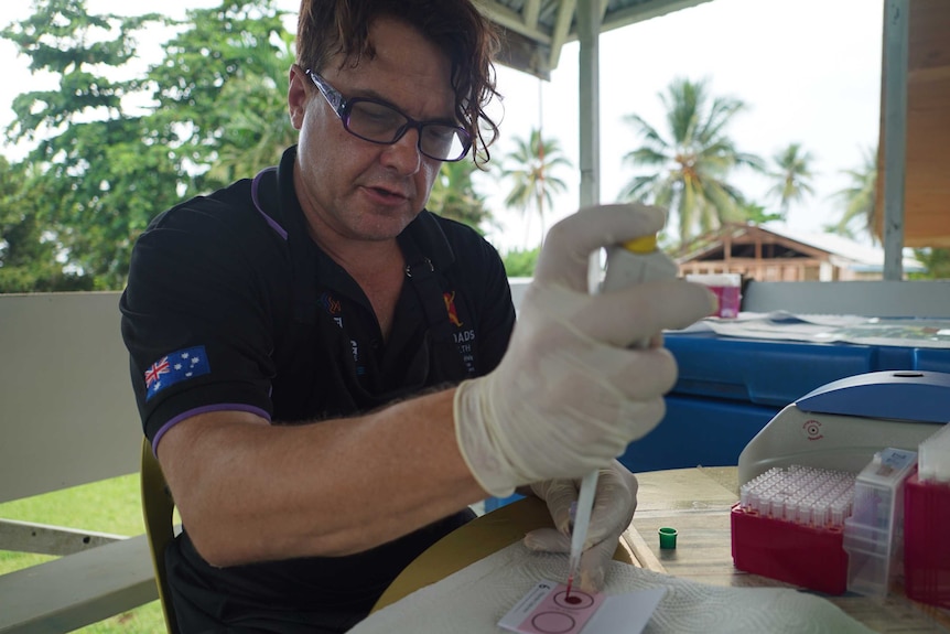 Associate Professor Bayden Wood from Monash University putting blood on test strips.