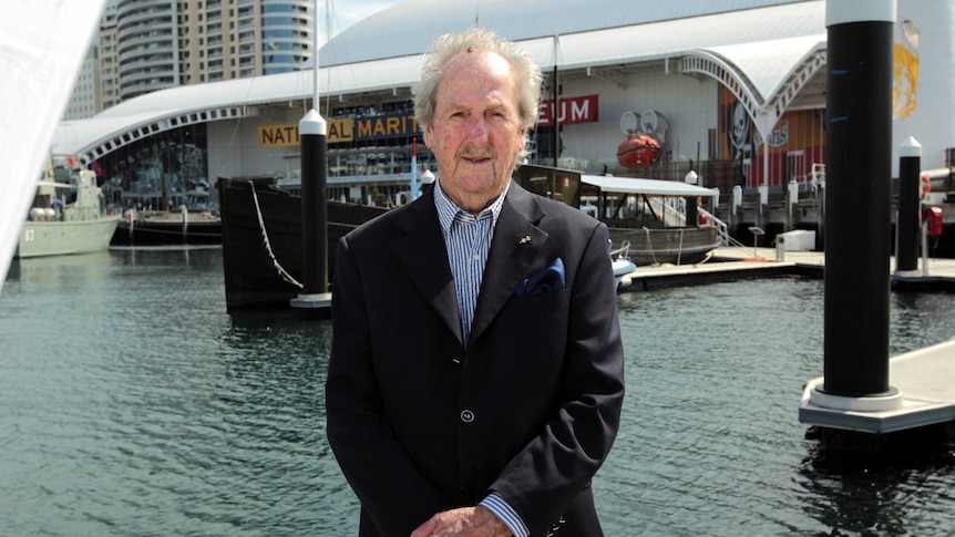 Douglas Herps stands in front of MV Krait in Darling Harbour