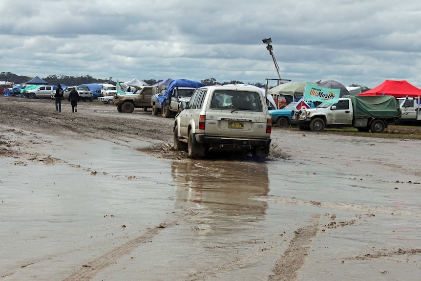 A 4WD drives through the mud in the camping area