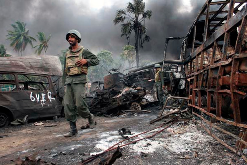 Soldiers walk through debris in the aftermath of a battle