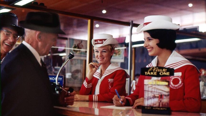 1960s photo of two Fremantle Port Authority hostesses talking to elderly couple at counter