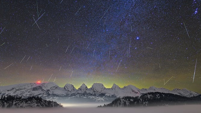 Hundreds of meteors captured on time lapse over a snowy mountain range