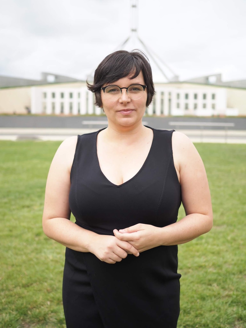 Erin Turner standing in front of Parliament House with her hands clasped together.