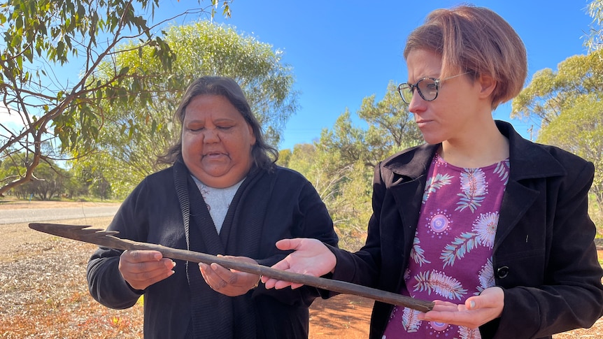 Two women holding a 160-year-old Aboriginal spear.
