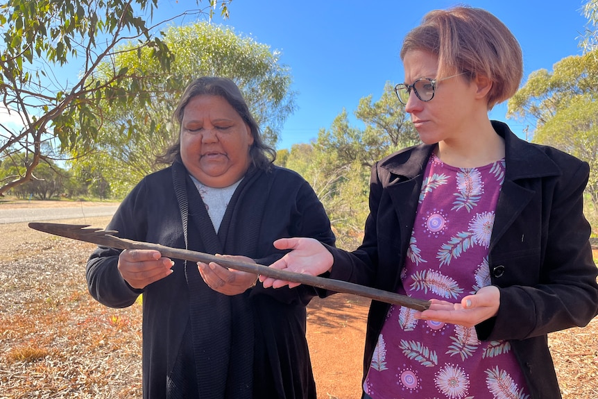 Two women holding a 160-year-old Aboriginal spear.