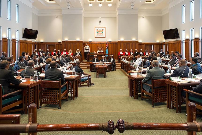 Parliament chambers in Fiji with politicians sitting on either side of the room