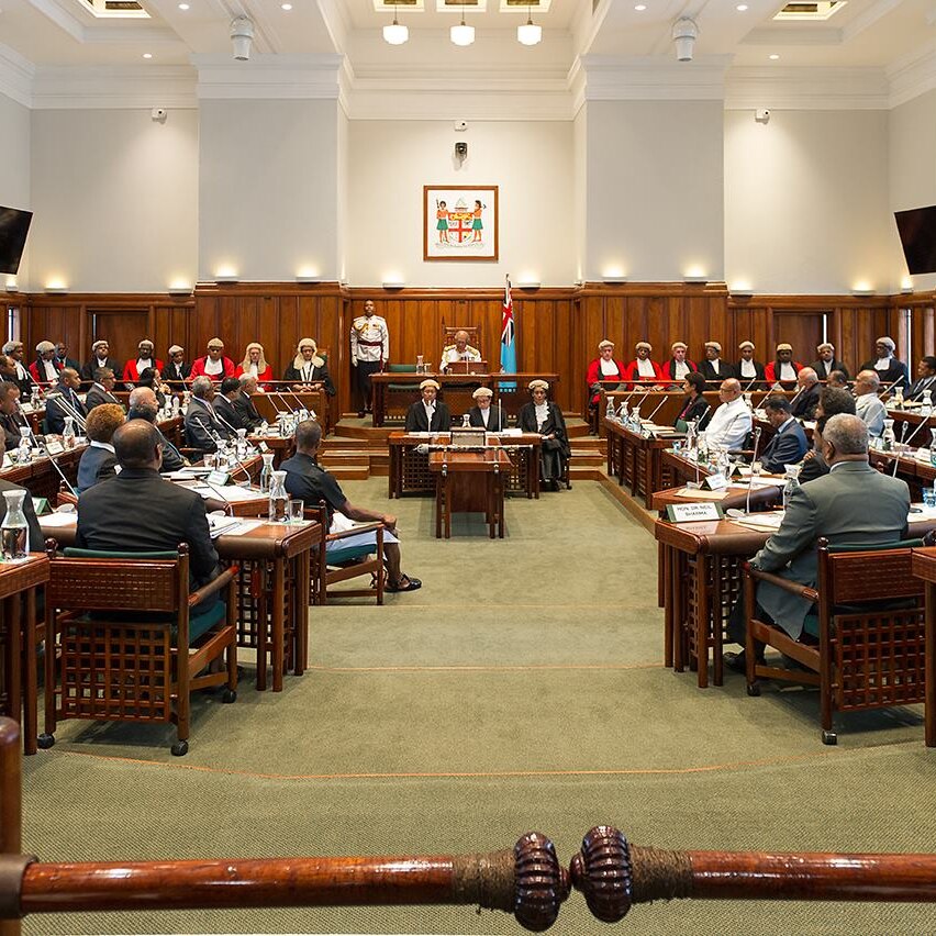Parliament chambers in Fiji with politicians sitting on either side of the room