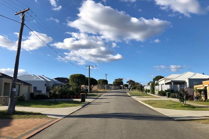 A wide street in Nollamara with new houses and very small trees.