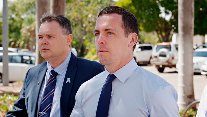 Constable Zachary Rolfe walks in front of another man outside the NT Supreme Court.