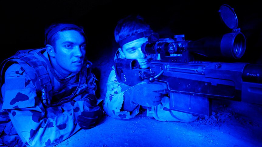 Two soldiers crouched in shooting position in a night shot