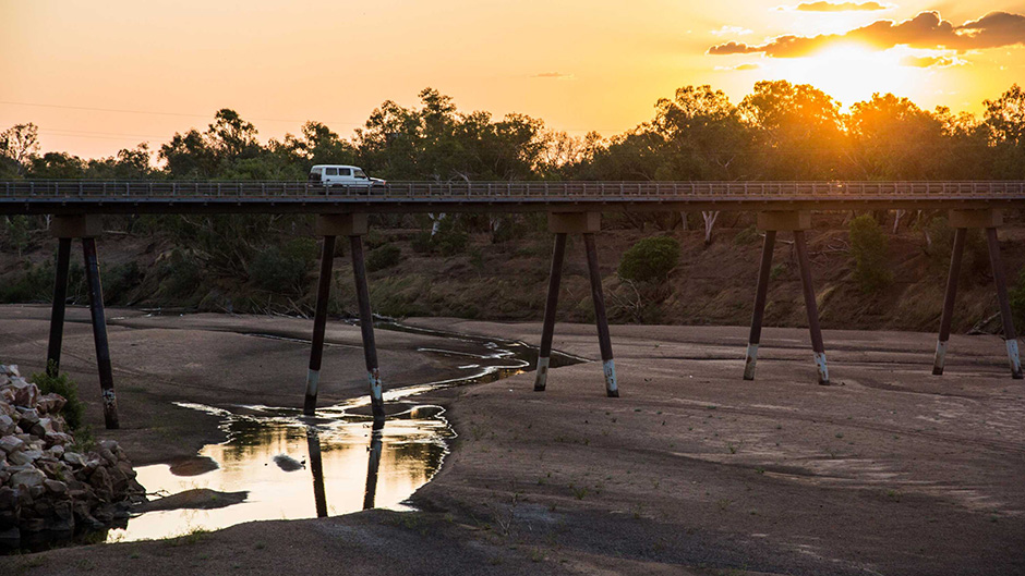 The Fitzroy River bakes to just a trickle as the sun sets on another 40-plus degree day in Fitzroy Crossing.