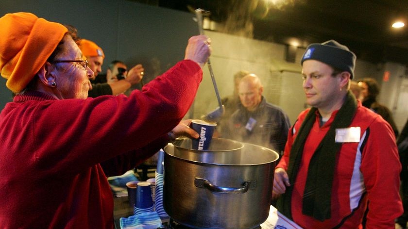 A Chief Executive Officer collects a cup of warm soup during the 2010 St Vincent de Paul CEO Sleepout at Luna Park in north Sydney on June 17, 2010. The CEO Sleepout challenges CEO's of firms to experience homelessness for a night to help raise money and awareness of the homeless.