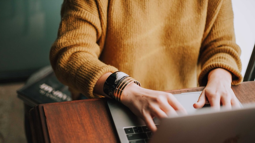 Woman's hands type on a laptop computer