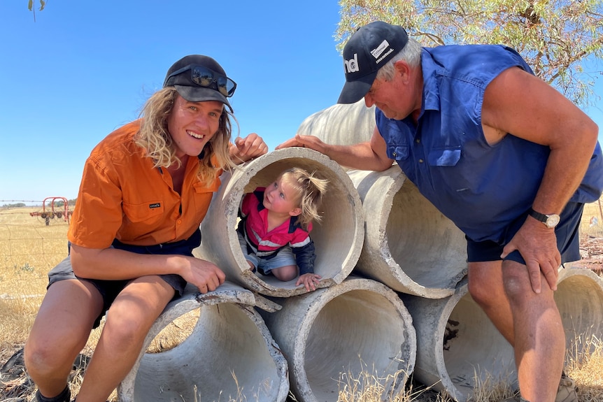 Photo of a family with a child in a construction pipe.