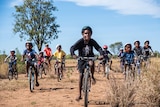 A group of young students ride bikes in the outback of the Northern Territory. 