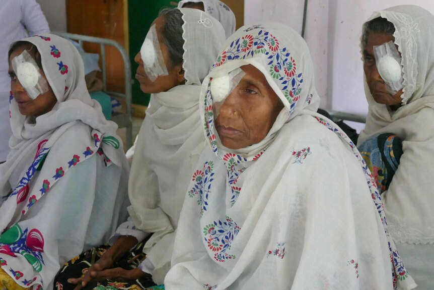 A group of women in hospital with surgical patches over their eyes