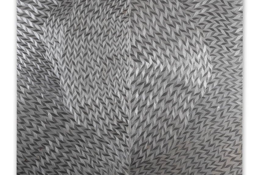An etched artwork showing silver and black patterns on metal 