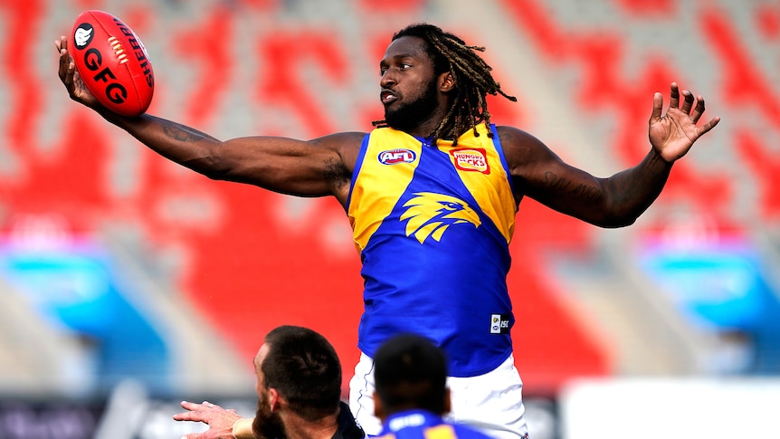 Athlete jumping for the ball during an AFL match