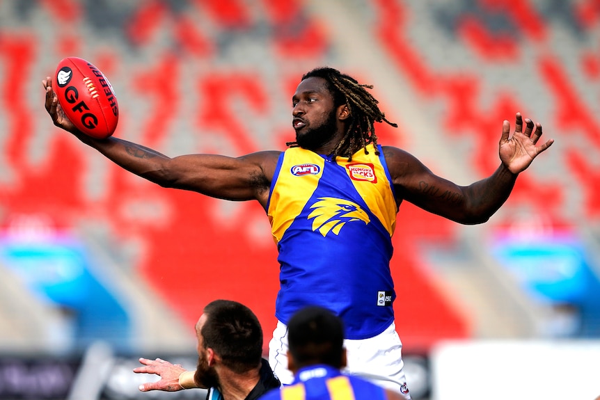 Athlete jumping for the ball during an AFL match