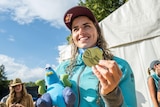 Jess Fox poses for a photo with her world championship gold medal, a hat and plushie