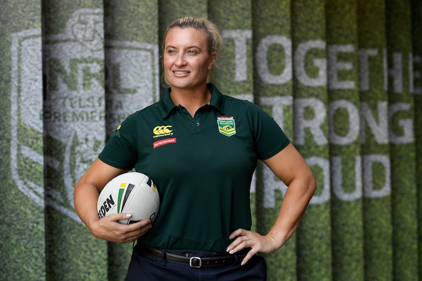 Ruan Sims poses for photographers holding a rugby league ball.