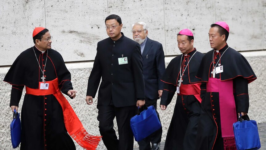 Chinese bishops Yang Xiaoting, second from right, and Guo Jincai, right, arrive with other prelates at the Synod Hall.