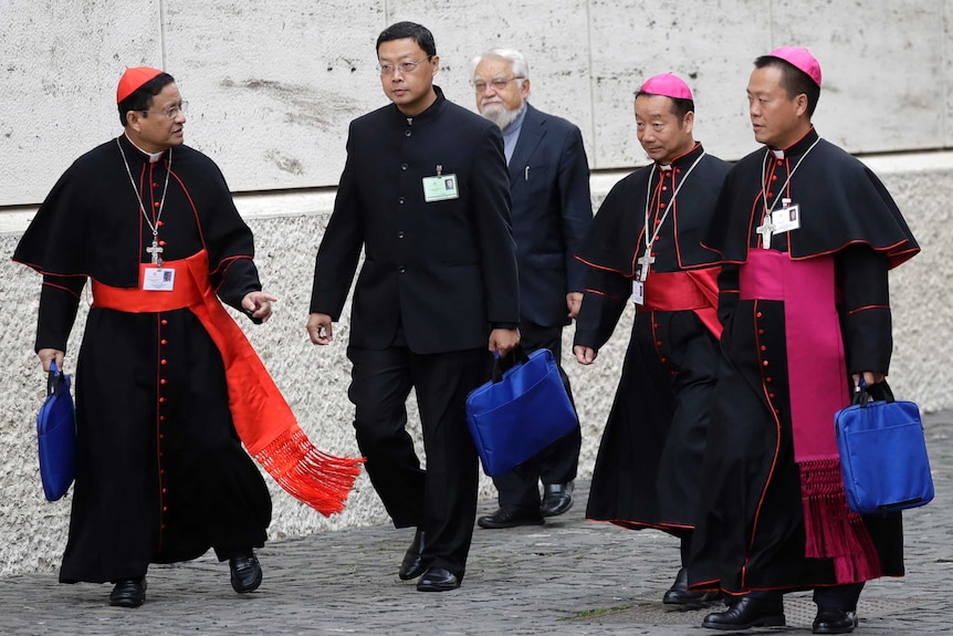 Chinese bishops Yang Xiaoting, second from right, and Guo Jincai, right, arrive with other prelates at the Synod Hall.