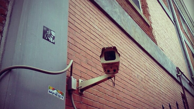 A surveillance camera on a red brick building.