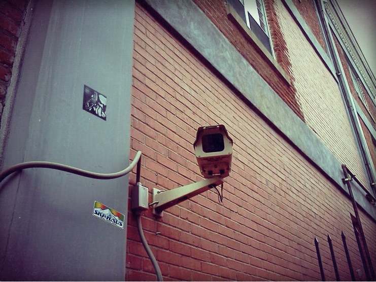 A surveillance camera on a red brick building.