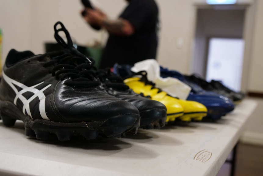 Pairs of football boots lined up on a table.